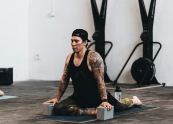 woman in black tank top and black pants sitting on black wooden table