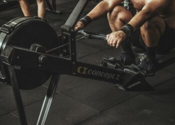 topless man using rowing machine