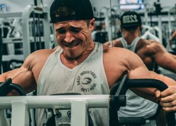 man in white tank top wearing black cap